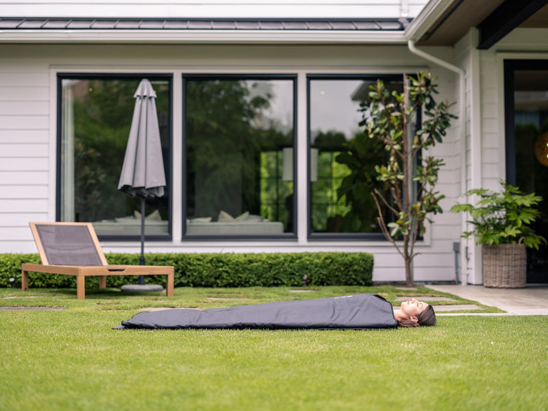 Person relaxing in an Orion Embers infrared sauna blanket