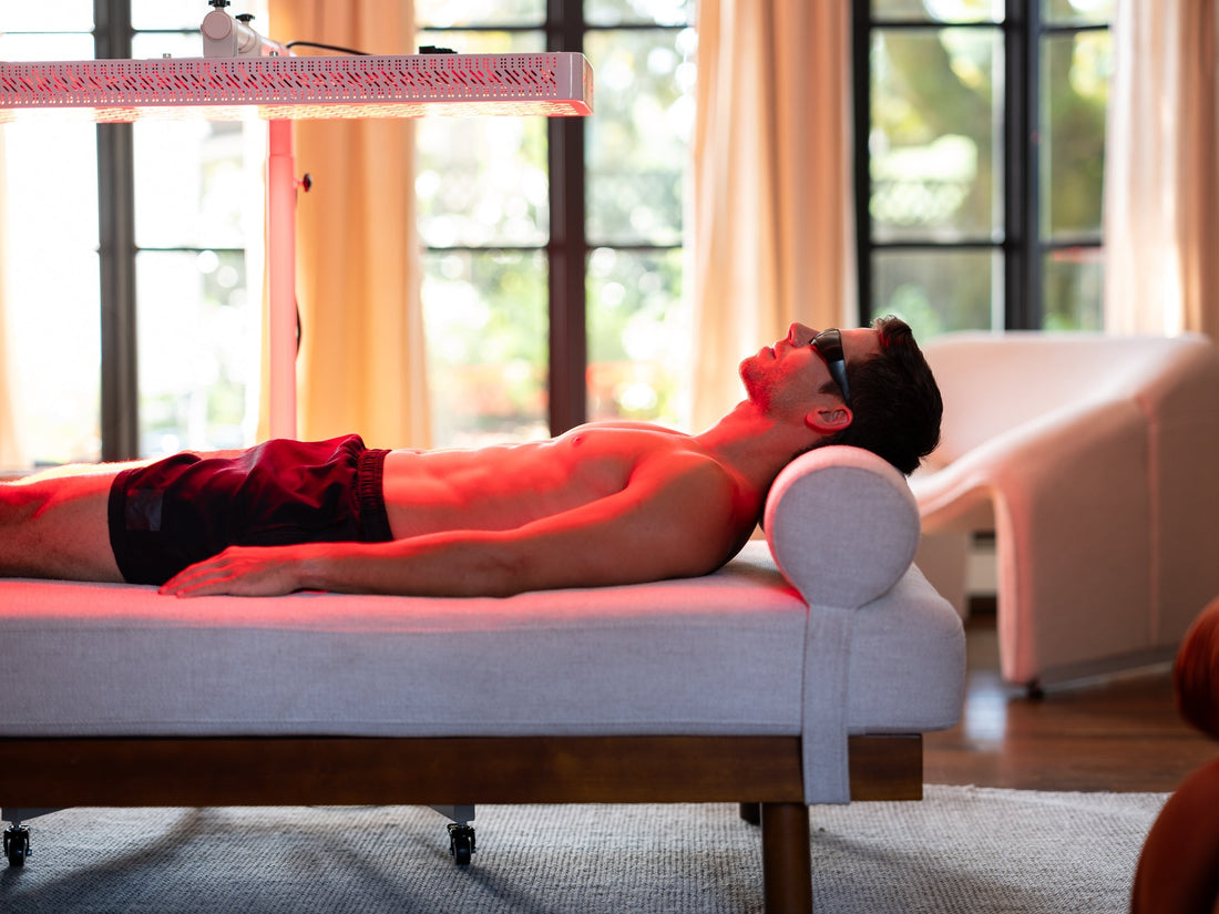 Man relaxing under an Orion red light therapy panel to reduce inflammation