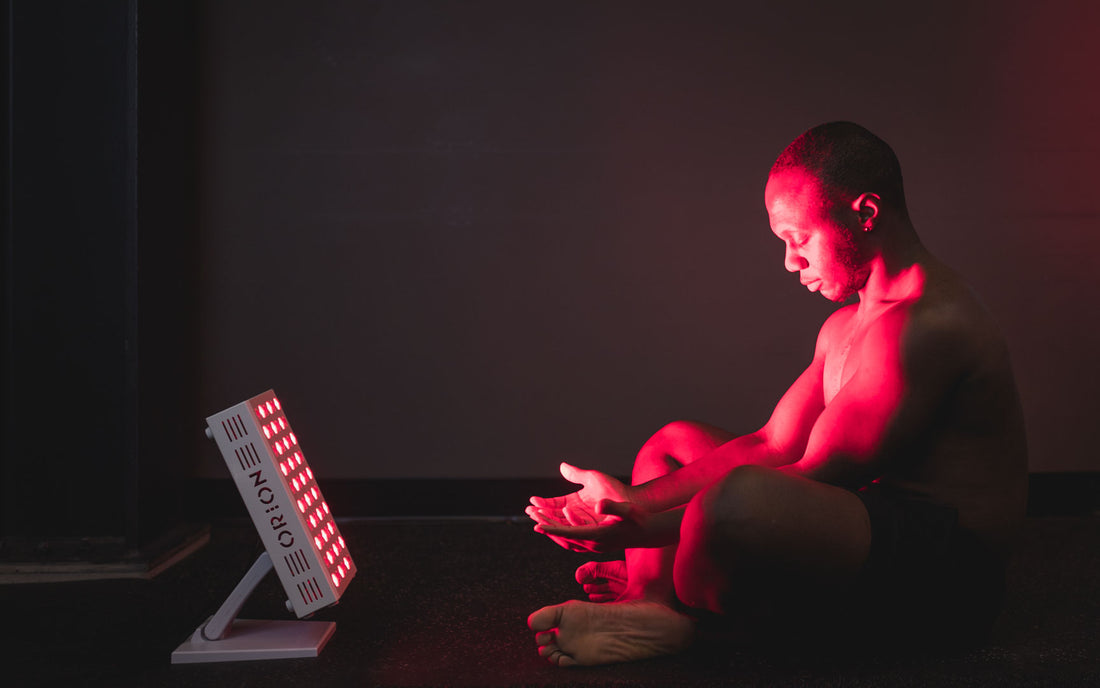 Man stretching in front of the Orion Pro 300 - Orion Red Light Therapy