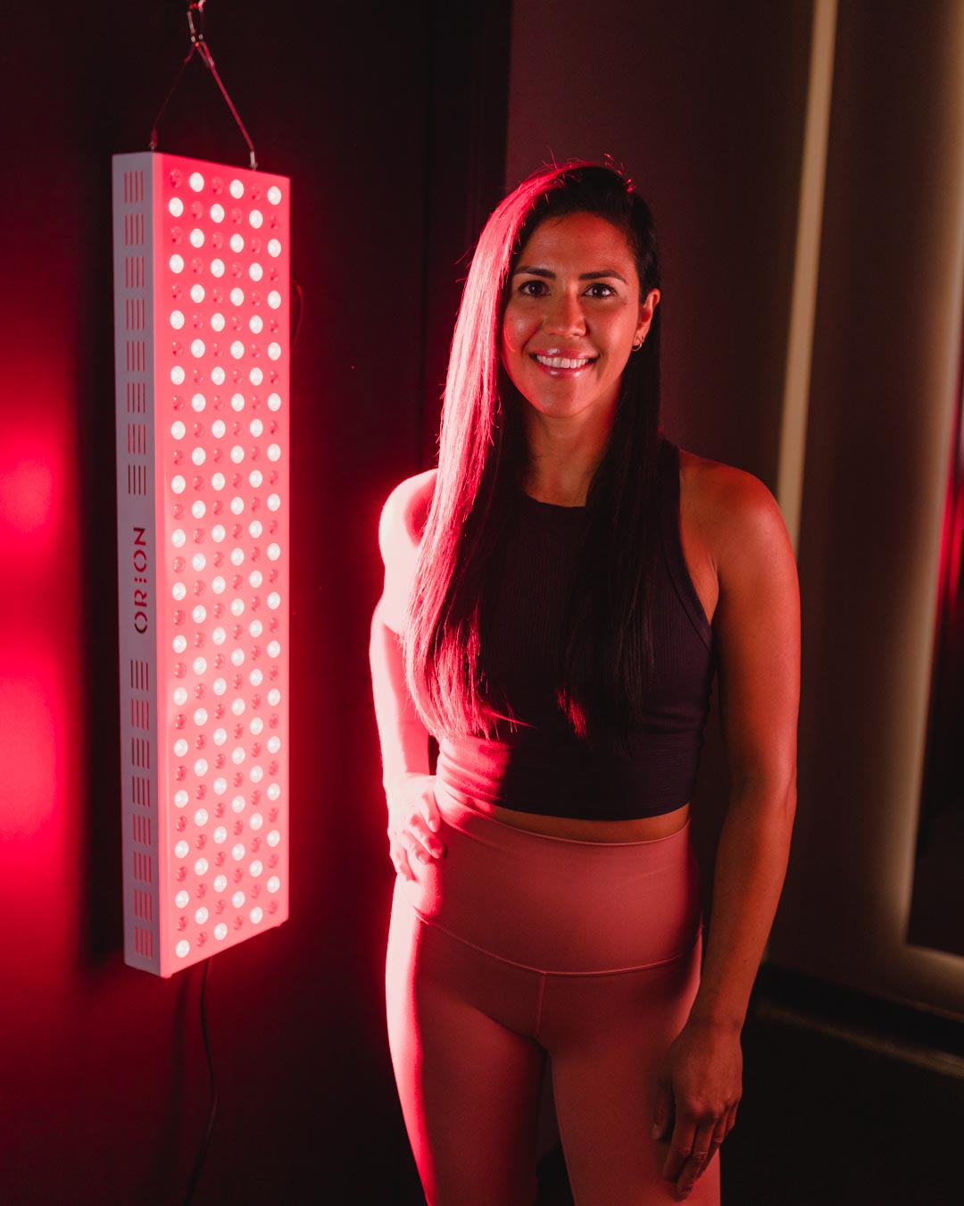 Orion Red Light Therapy - woman standing in front of the Orion Pro 900